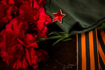 Carnations, cap and St. George ribbon, on the background of marble