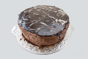 Chocolate cake with chocolate fudge drizzled icing on a tray.