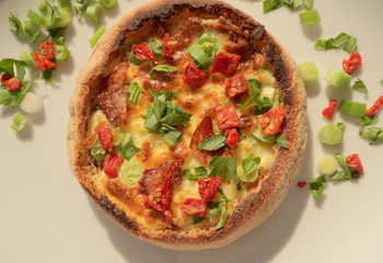 Tasty italian pizza with bacon, green spring onions, melted cheese