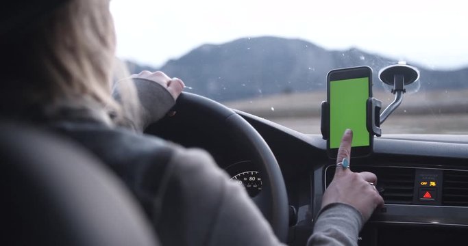 Female rideshare driver accepts trip on phone app with car mount