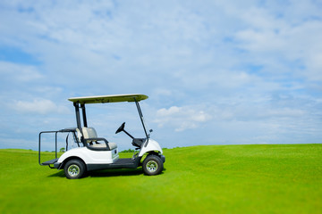 Golf cart in golf course and green grass with soft cloud sky for background backdrop use