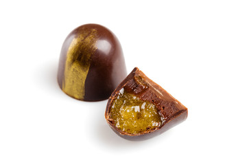 Cut luxury handmade bonbons with chocolate ganache and citrus fruit jelly filling isolated on white background