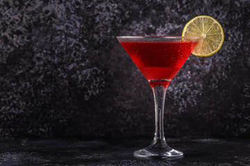 Glass of cosmopolitan cocktail decorated with lime