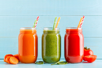 Orange/green/red colored smoothies / juice in a jar