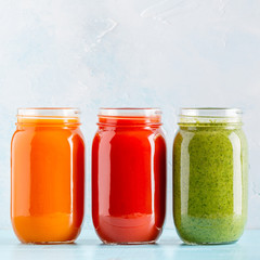 Orange/green/red colored smoothies / juice in a jar