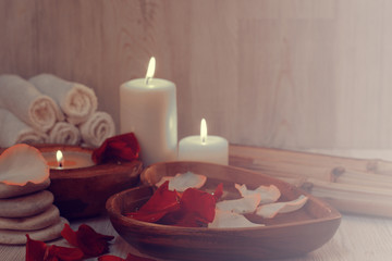 Romantic atmosphere before the spa treatments with burning candles, rose petals and a light haze of incense