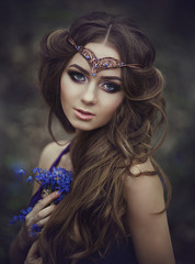 Portrait of a girl elf with long hair and blue eyes, wears a tiara with a bouquet of spring flowers...