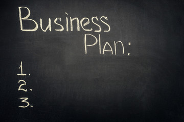 Business plan inscription with stages list on dark chalkboard