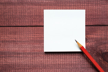 Sticky notes next to a blank sheet of paper. Supplies stationery on a wooden texture table. Trendy minimalism. Top view