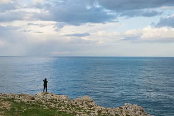 Fototapeta na wymiar uomo sulla roccia sul mare