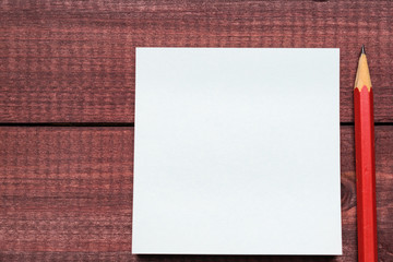 Sticky notes next to a blank sheet of paper. Supplies stationery on a wooden texture table. Trendy minimalism. Top view