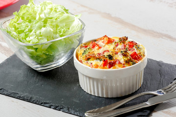 quiche with broccoli, cheese and tomatoes, salad background