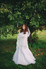 Fototapeta premium beautiful bride in a lace shawls on the nature