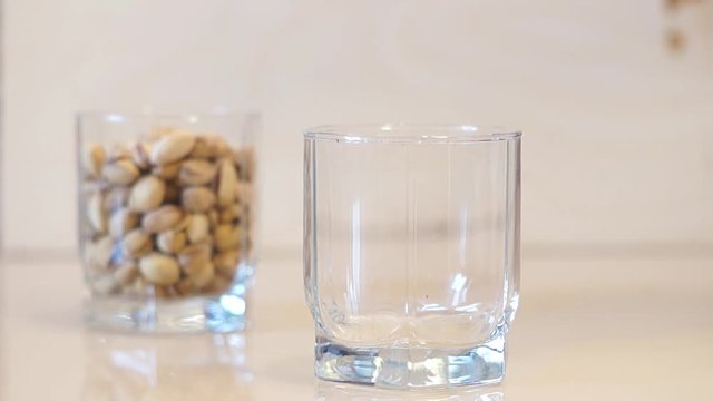 Pistachios. Pouring pistachios. Pistachio nuts falling into glass