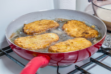 Frying torrijas. It consists of a slice of bread that is soaked in milk or wine and, after being coated in egg, fried in a pan with oil. It is sweetened with sugar and is flavored with cinnamon.
