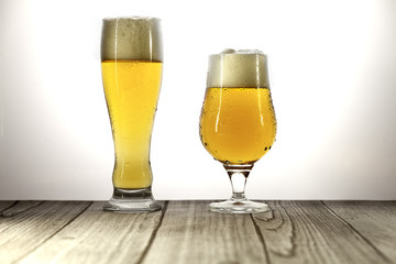 long glass and glass of beer with foam