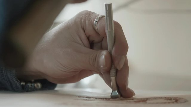 Leather master manufacturer working on handmade bag. Craftsman knocks with hammer to stick two parts. Manufacture goods at home. Close up hands using instrument. 4k