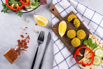 Fototapeta na wymiar Homemade falafel balls,sweet red pepper and green fresh parsley Traditional Middle Eastern food.