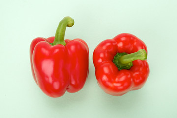 Side, top view of red bell pepper on colored background