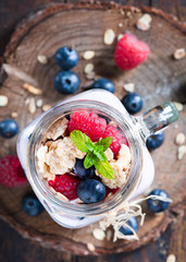 Combined fruit and yogurt in glass with rustic background.