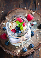 Combined fruit and yogurt in glass with rustic background.