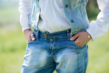 Fashionable girl in jeans dress on a background of nature