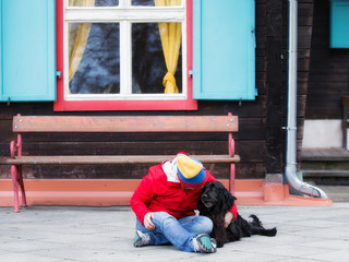 Women sitting on the ground with her dog flat coated retriever