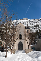 Iglesia en la monta&ntilde;a con &aacute;rboles delante y nieve