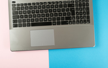 Laptop over pink and blue background. Technology.