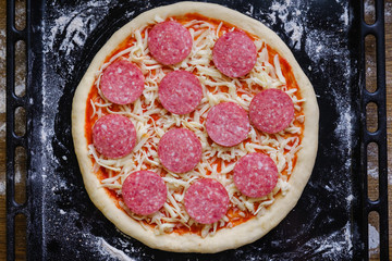 Fresh original Italian raw pizza, preparation on a baking tray in the oven