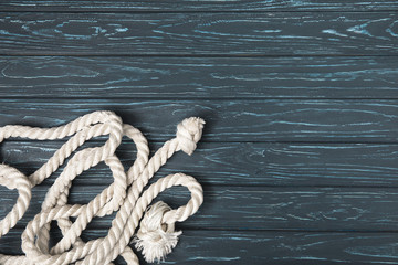 top view of knotted white nautical rope on wooden planks