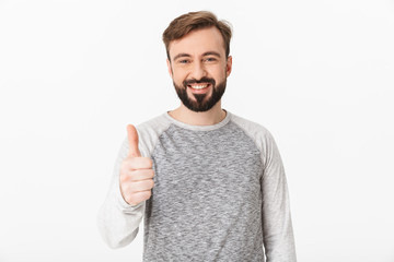 Cheerful young man showing thumbs up.