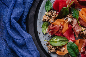 top view of fresh gourmet salad with mussels, root vegetables and jamon