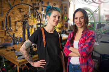 Two young women working in a bicycle repair shop
