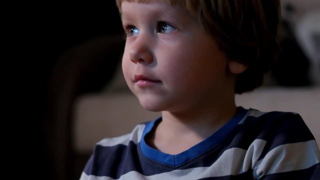 Boy watching television in dark living room