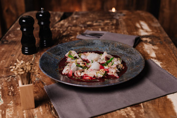 close-up view of delicious Ceviche with dorado and daikon on wooden table in restaurant