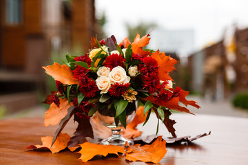 autumn flower composition with roses, chrysanthemum and maple leaves
