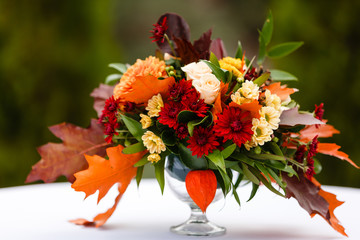 autumn flower composition with roses, chrysanthemum and maple leaves