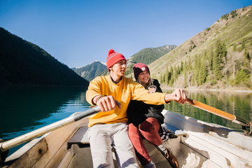Couple in love swim in a boat on a mountain lake