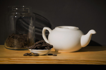 white ceramic teapot and chocolate