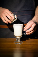 Hand on the barista, making a latte cafe, a cup of coffee with a beautiful latte