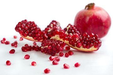 Cut-up dissected tasty pomegranate with seeds isolated on white background