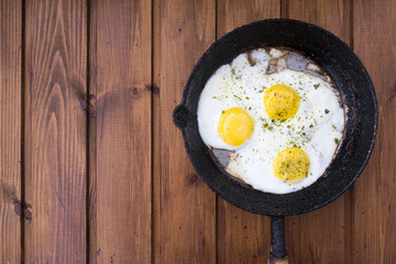 appetizing fried eggs in an old frying pan