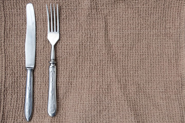 A knife and fork is located on the towel and a place for recording the recipe.