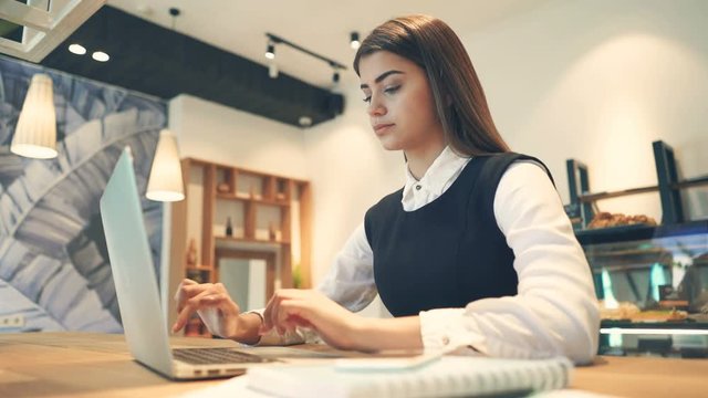 The beautiful woman working with a laptop and phones