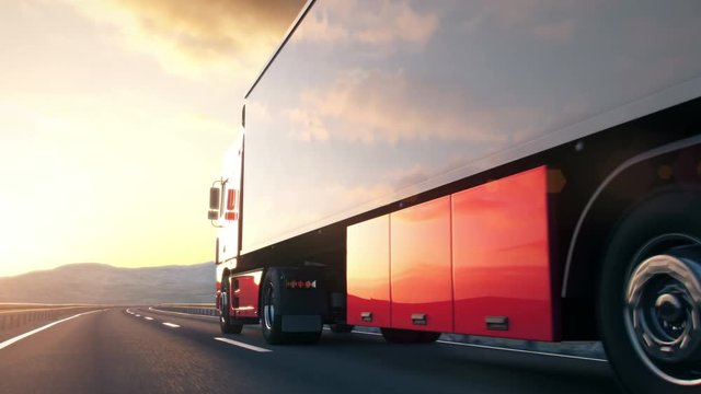 semi trailer truck driving along a desert road into the sunset
