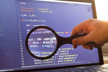 PHP back-end code zoomed through a magnifier. Computer programming source code lookup. Abstract...
