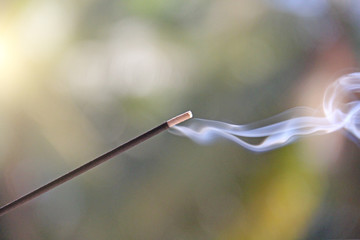 Incense stick and smoke from incense burning. Beautiful smoke. Blurred background and design with...