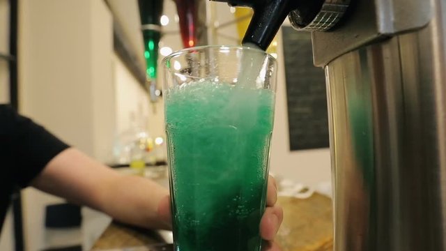 Man adding water green syrup and stirring, mixing ingredients, party cocktails