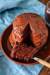 Chocolate pancakes with syrup in a plate on a blue background.